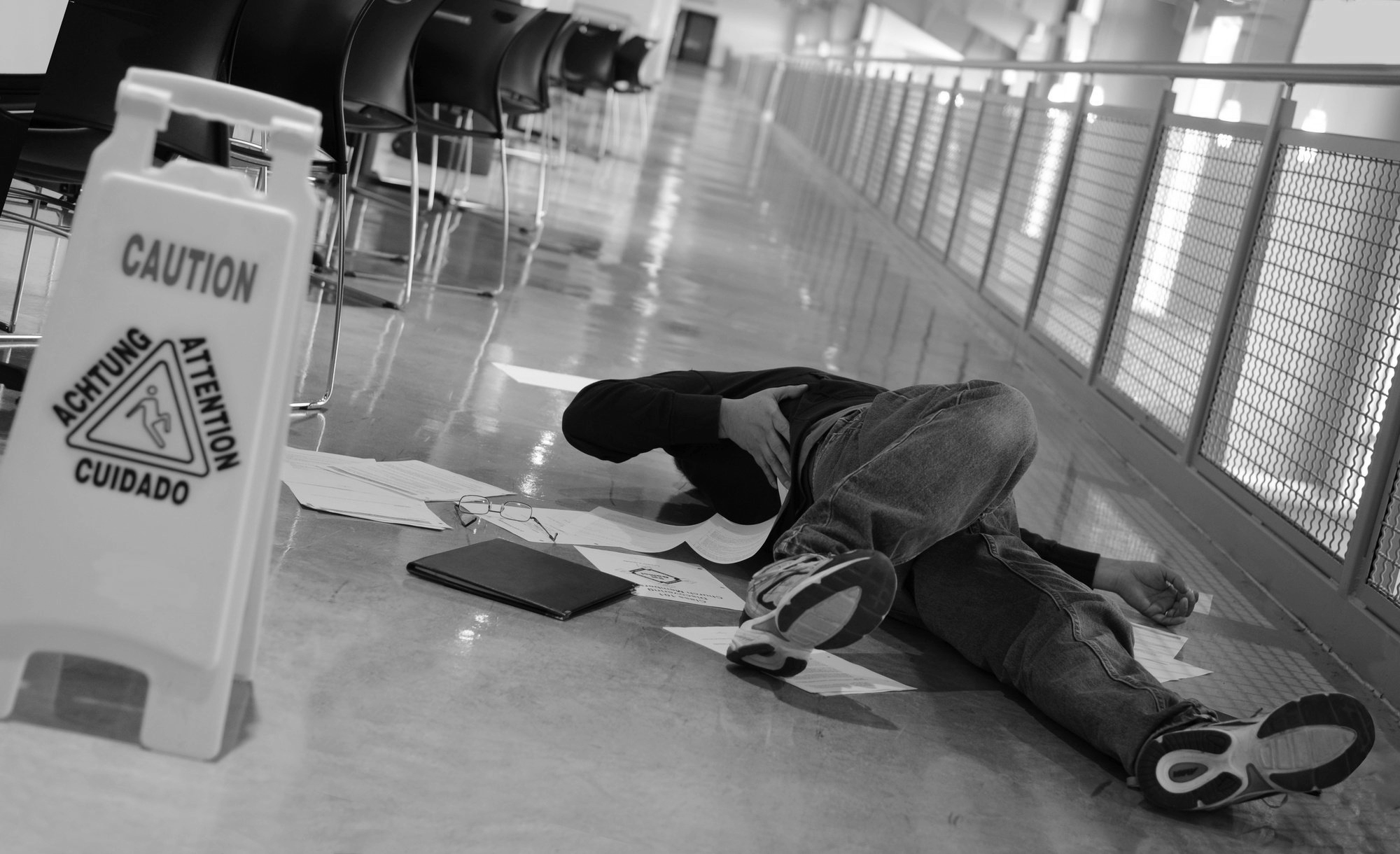 Picture of man laying on floor after falling with papers scattered around him